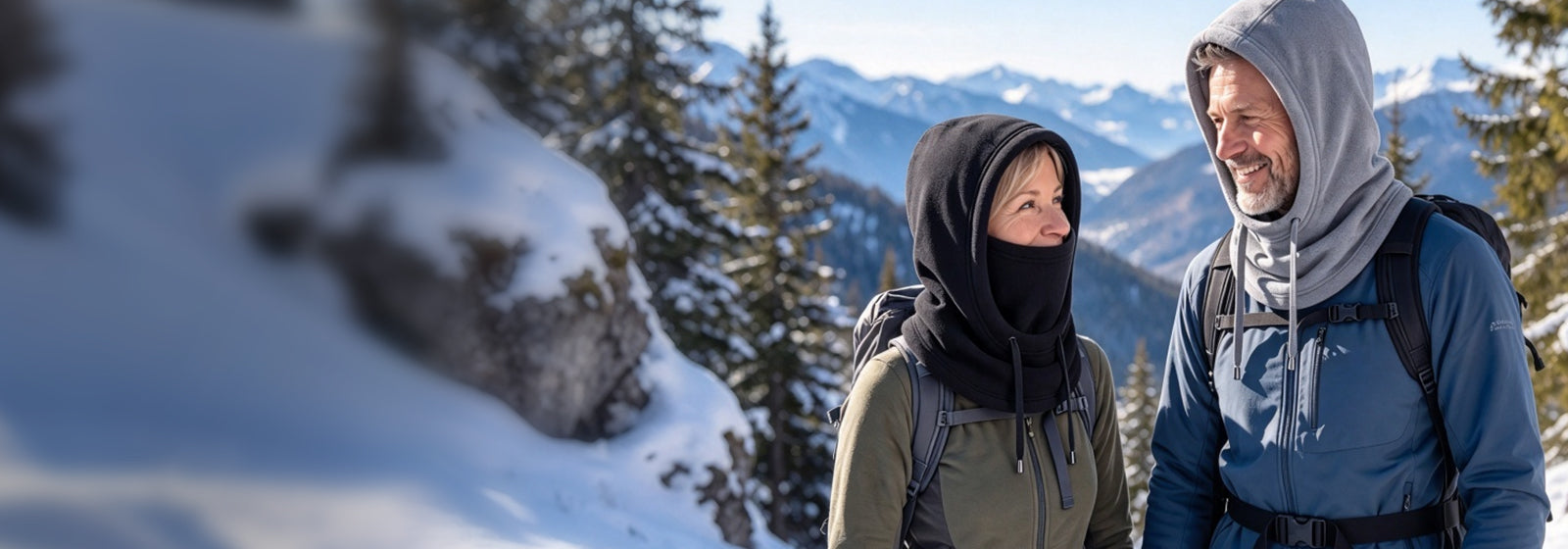 Couple wearing thermal balaclavas on a snowy mountain walk