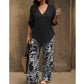 Un completo composto da una blusa da donna con scollo a V e pantaloni a gamba larga con fantasia.